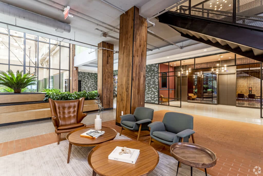 lobby lounge with elevators, social seating, large windows and modern artwork at the garrett apartments in washington dc