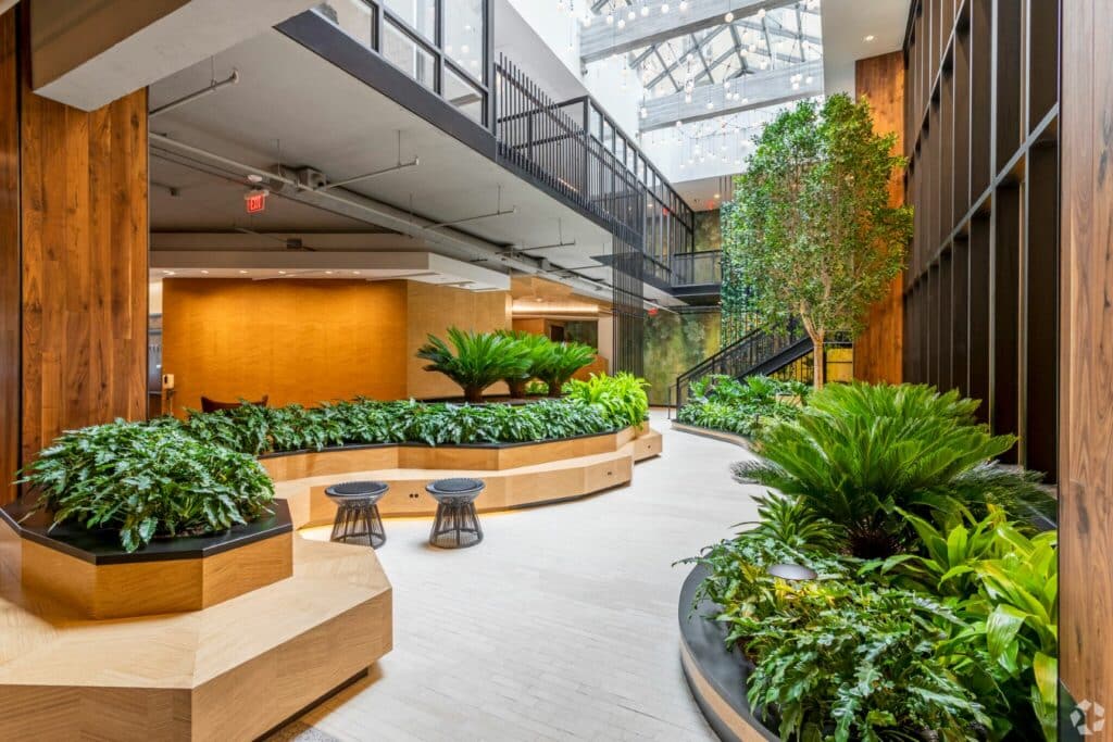 indoor atrium with trees, plants and social seating at the garrett apartments in washington dc