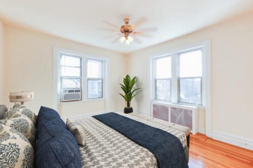 bedroom with bed, windows, wood floors and ceiling fan at chatham courts apartments in adams morgan washington dc