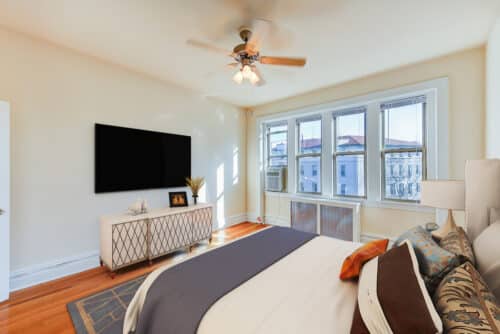 bedroom with bed, nightstands, dresser and large windows at chatham courts apartments in adams morgan washington dc