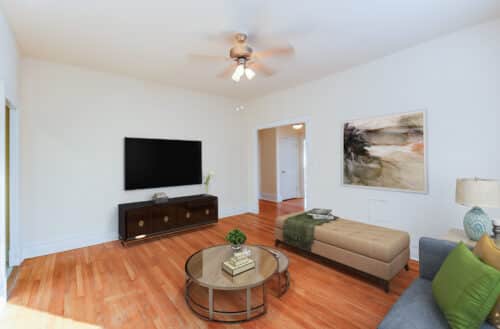 living area with sofa, coffee table, credenza, tv, wood floors and ceiling fan at chatham courts apartments in adams morgan washington dc
